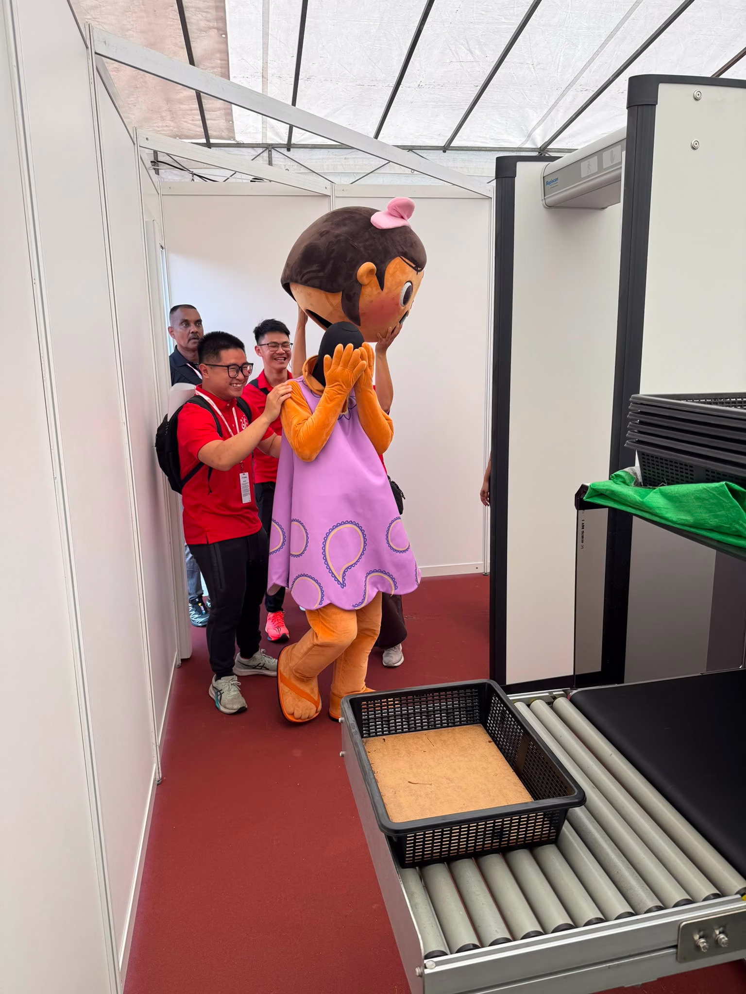 SG NDP 2026 Mascot undergoing a security screening by AP.